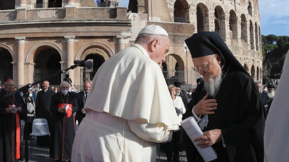los lideres catolico y ortodoxo se saludan formalmente. al fondo el coliseo romano